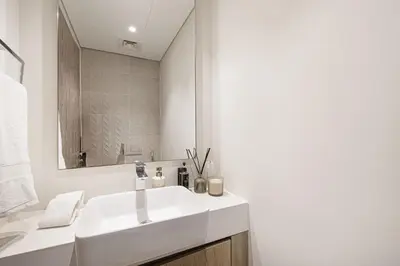 a white bathroom with a sink and a mirror at Daniels 2BR with Maid Room at Liv Residency with Marina View in Dubai