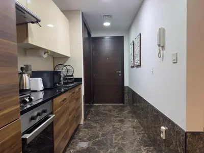 a kitchen with a hallway leading to a door at Studio Apartment in Sparkle Tower Dubai Marina in Dubai