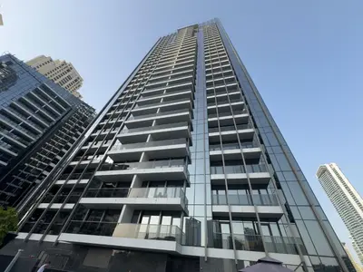 a tall building with glass windows in a city at Studio Apartment in Sparkle Tower Dubai Marina in Dubai