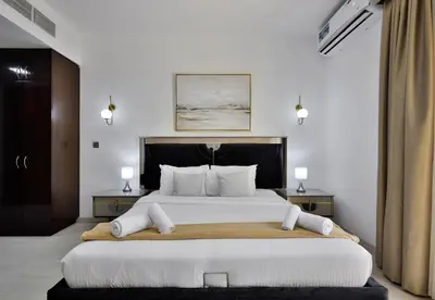 a bedroom with a large white bed with white pillows at 5BR & Maids Room with Private Pool in The Aldea, The Villa - Allsopp & Allsopp in Dubai