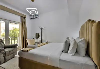 a bedroom with a large bed and a chair at 5BR & Maids Room with Private Pool in The Aldea, The Villa - Allsopp & Allsopp in Dubai