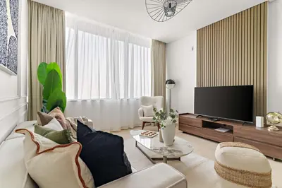 a living room with a couch and a tv at Silkhaus Comfy 1BDR at Sky Gardens in DIFC-NEW in Dubai