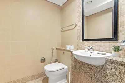 a bathroom with a toilet and a sink and a mirror at Silkhaus Comfy 1BDR at Sky Gardens in DIFC-NEW in Dubai
