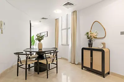 a dining room with a table and a mirror at Silkhaus Luxury Studio at Sky Gardens in DIFC Views in Dubai