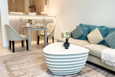 a living room with a couch and a table at Spacious 1 bed with seaview in Seven Palm - Palm Jumeirah - IQPRO Holidays in Dubai