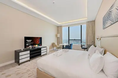a hotel room with a bed and a flat screen tv at NEW Luxury studio - Amazing Palm Views in Dubai