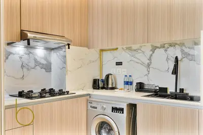 a kitchen with a stove and a washing machine at Bookable - Studio Room, Bali Residences JVT in Dubai