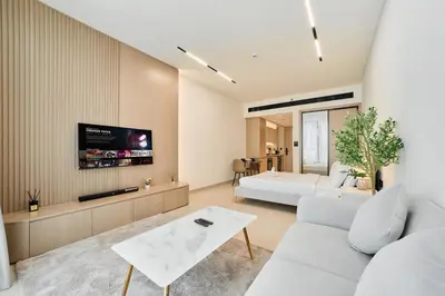 a living room with a white couch and a tv at Chic Studio in Dawn by Binghatti, Heart of JVC in Dubai