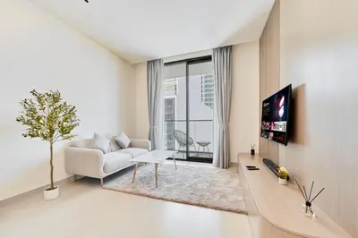 a living room with a white couch and a tv at Chic Studio in Dawn by Binghatti, Heart of JVC in Dubai