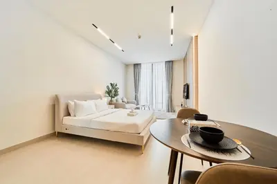 a living room with a couch and a table at Chic Studio in Dawn by Binghatti, Heart of JVC in Dubai