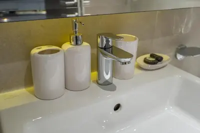 a sink with three rolls of paper towels and a faucet at Chic Canal-ViewStudio by Czechin Pool & Gym Access in Dubai