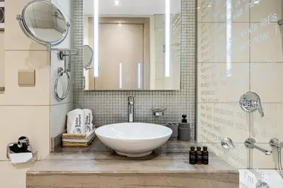 a bathroom with a large white sink and a mirror at BLVD - Luxury Stay with Burj Khalifa View in Dubai