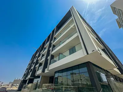 a building with glass windows on the side of it at Welhome - Modern Gold Accents Studio in JVC with Balcony in Dubai