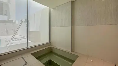 a room with a pool of water in a shower at Welhome - Modern Gold Accents Studio in JVC with Balcony in Dubai