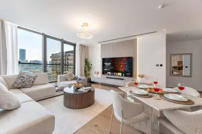 a living room with a couch and a table at 2BDR with Pool, Sauna and PS5 - Near Circle Mall in Dubai