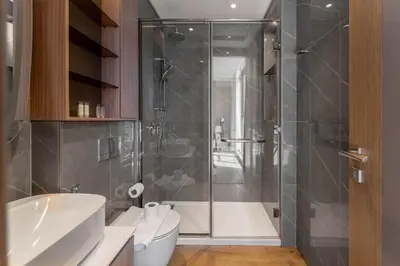 a bathroom with a shower and a toilet and a sink at 2BDR with Pool, Sauna and PS5 - Near Circle Mall in Dubai