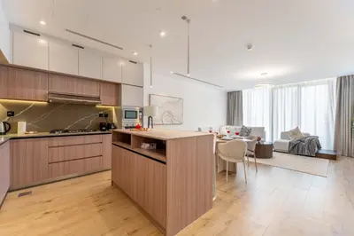a kitchen and living room with a dining room at 2BDR with Pool, Sauna and PS5 - Near Circle Mall in Dubai