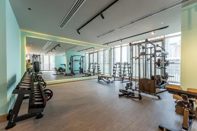 a gym with treadmills and machines in a building at 2BDR with Pool, Sauna and PS5 - Near Circle Mall in Dubai