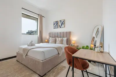 a bedroom with a large bed and a table and chairs at Walking Distance to Circle Mall and Community Parks, 18 Minute Drive to Dubai Marina and JBR Beach, Crystal Residence, JVC by Deluxe Holiday Homes in Dubai