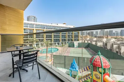 a balcony with a table and chair on a building at Walking Distance to Circle Mall and Community Parks, 18 Minute Drive to Dubai Marina and JBR Beach, Crystal Residence, JVC by Deluxe Holiday Homes in Dubai