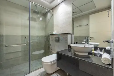 a bathroom with a sink and a toilet and a shower at Walking Distance to Circle Mall and Community Parks, 18 Minute Drive to Dubai Marina and JBR Beach, Crystal Residence, JVC by Deluxe Holiday Homes in Dubai