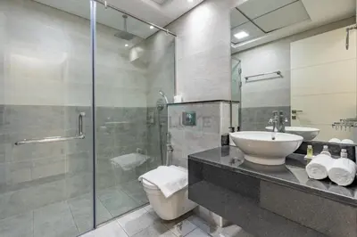 a bathroom with a toilet and a sink and a shower at Walking Distance to Circle Mall and Community Parks, 18 Minute Drive to Dubai Marina and JBR Beach, Crystal Residence, JVC by Deluxe Holiday Homes in Dubai
