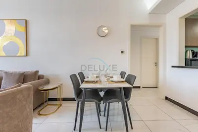 a dining room with a table and chairs at Walking Distance to Circle Mall and Community Parks, 18 Minute Drive to Dubai Marina and JBR Beach, Crystal Residence, JVC by Deluxe Holiday Homes in Dubai