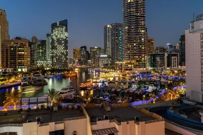a view of a city at night with a harbor at Inviting Dubai Marina Studio near Beach and Canal in Dubai