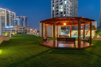 a gazebo with benches in a city at night at Inviting Dubai Marina Studio near Beach and Canal in Dubai