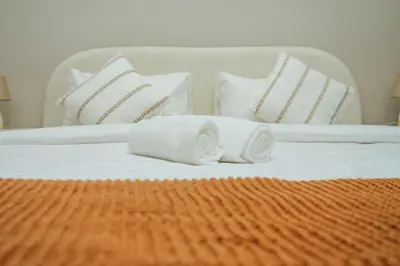 a bed with white pillows and towels on it at Apt in Trillionaire Residences with Private Jacuzzi in Dubai