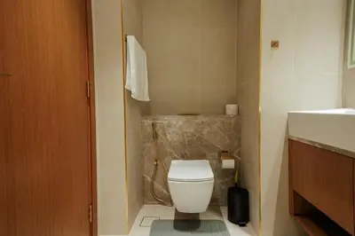 a bathroom with a white toilet and a sink at Apt in Trillionaire Residences with Private Jacuzzi in Dubai