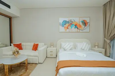 a white bedroom with a bed and a couch at Apt in Trillionaire Residences with Private Jacuzzi in Dubai