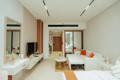 a living room with a white couch and a tv at Apt in Trillionaire Residences with Private Jacuzzi in Dubai