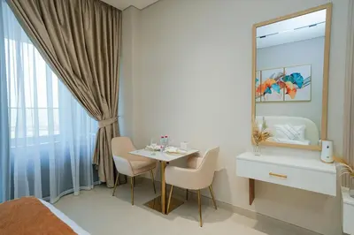 a bedroom with a table and chairs and a mirror at Apt in Trillionaire Residences with Private Jacuzzi in Dubai