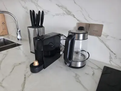 a black coffee maker on a counter next to a sink at Serene Ocean Views 2BR Emaar Beachfront in Dubai