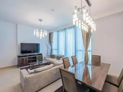 a living room with a dining table and a television at Downtown views 1 Bedroom 5 PAX connect to Dubai mall in Dubai