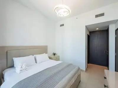a bedroom with a large white bed in a room at Downtown views 1 Bedroom 5 PAX connect to Dubai mall in Dubai