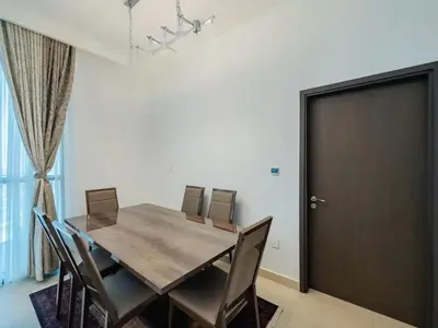 a dining room with a wooden table and chairs at Downtown views 1 Bedroom 5 PAX connect to Dubai mall in Dubai