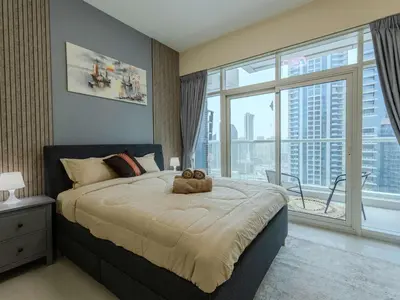 a bedroom with a large bed with a large window at Continental Tower Luxury 2BR Dubai Marina Views in Dubai