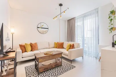 a living room with a couch and a table at Serene and Stylish Home in the Heart of JVC in Dubai