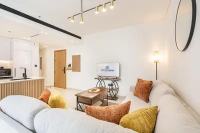 a living room with a couch and a table at Serene and Stylish Home in the Heart of JVC in Dubai
