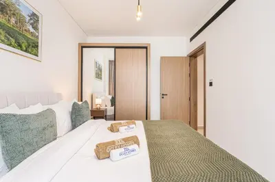 a bedroom with a bed with two towels on it at Serene and Stylish Home in the Heart of JVC in Dubai