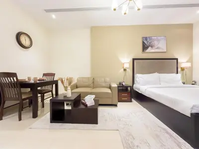 a bedroom with a bed and a couch and a table at Elite Residency- A Cosy Studio in Downtown in Dubai