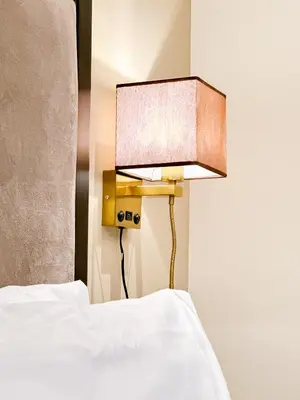 a lamp on a wall next to a bed at Elite Residency- A Cosy Studio in Downtown in Dubai