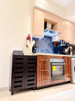 a kitchen with wooden cabinets and a microwave at Elite Residency- A Cosy Studio in Downtown in Dubai
