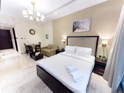 a bedroom with a large bed and a living room at Elite Residency- A Cosy Studio in Downtown in Dubai