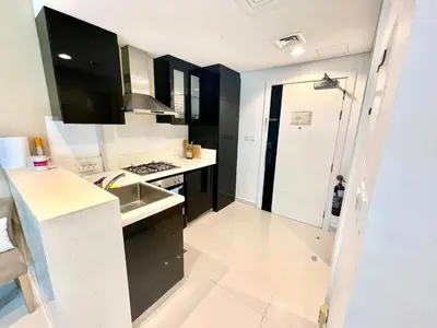 a kitchen with a sink and a stove top oven at Luxury Studio with Pool, Gym & Downtown Access in Dubai