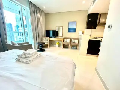 a hotel room with a bed and a kitchen at Luxury Studio with Pool, Gym & Downtown Access in Dubai