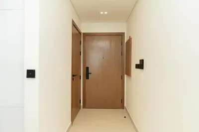 a hallway with a wooden door in a building at Binghatti Amber in JVC, 15 Min to Marina in Dubai