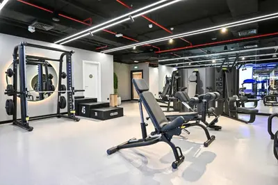 a gym with several treadmills and cardio machines at Modern 1BR w Balcony & Great Amenities JVC in Dubai
